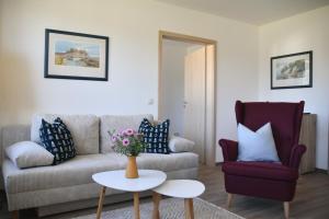 a living room with a couch and a table and a chair at Apartment Ferientiet in Bergen auf Rügen