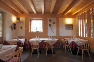 una habitación con mesas y sillas en un restaurante en Ciasa Vervei, en Cortina dʼAmpezzo