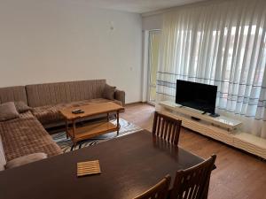 uma sala de estar com um sofá e uma mesa em Apartment në qendër të Gjilanit em Gjilan