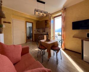 sala de estar con sofá y mesa con sillas en Appartamento Try on Lake Como with Balcony, en Lezzeno
