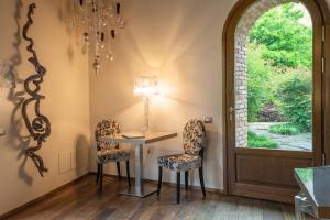 una sala da pranzo con tavolo, due sedie e una finestra di Il Borgo - 1711 Luxury Guest House ad Arlate