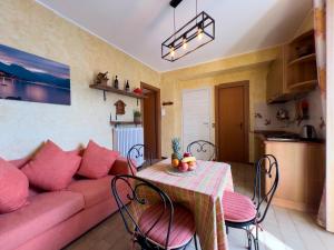 sala de estar con sofá rosa y mesa en Appartamento Try on Lake Como with Balcony, en Lezzeno