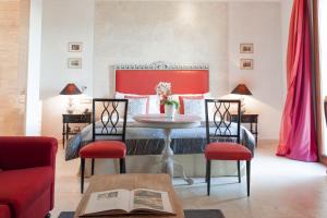 - une chambre avec un lit, une table et des chaises dans l'établissement Castello di Velona Resort, Thermal SPA & Winery, à Montalcino
