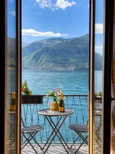una mesa en un balcón con vistas al agua en Appartamento Try on Lake Como with Balcony, en Lezzeno