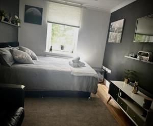 een slaapkamer met een groot bed en een raam bij Inviting 2-Bed Apartment in South Croydon in Purley