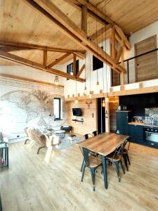 ein großes Wohnzimmer mit einem Holztisch und Stühlen in der Unterkunft Cocon de caractère au cœur des vignes Alsaciennes in Bergheim