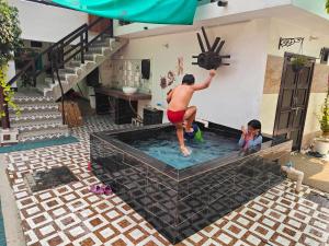 a man standing in a swimming pool in a house at Shobhayan inn in Ayodhya