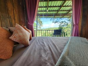 1 dormitorio con 1 cama y ventana grande en Rumhaoy Maison en Phumĭ Pu Pal