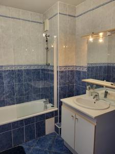 a blue tiled bathroom with a sink and a tub at Maison à 700m de la mer in Bormes-les-Mimosas +16 photos