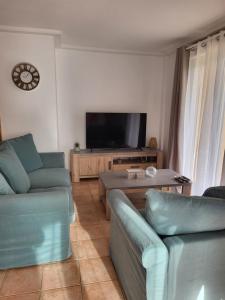 a living room with two couches and a flat screen tv at Maison à 700m de la mer in Bormes-les-Mimosas