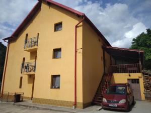 a house with a car parked in front of it at Casa MILOS SI FIUL in Băile Herculane