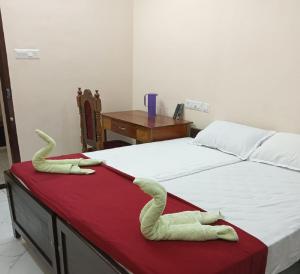two towels on a bed in a room at SRI PADMANABHA TOURIST HOME in Chacka