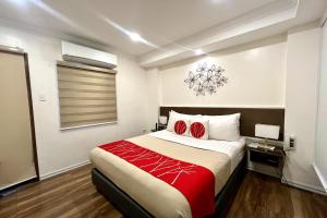 una camera da letto con un grande letto con una coperta rossa di Khotel Pasay a Manila