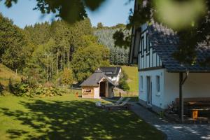 una casa con un banco junto a un patio en Ferienhaus Fichtenhütte en Finnentrop