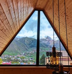 a window in a room with a view of mountains at Luno Cottage in Stepantsminda