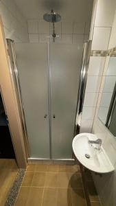 La salle de bains est pourvue d'une douche et d'un lavabo. dans l'établissement Nu Wave Hotel Berlin, à Berlin
