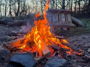 Bell tent Binnen Duin في 't Horntje: النار في المخيم مع مقاعد في الخلف