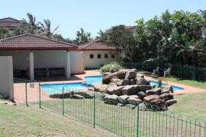 une clôture en face d'une maison avec piscine dans l'établissement Beachfront Paradise, à Tinley Manor