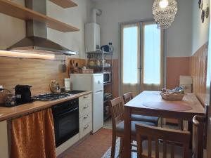 cocina con mesa y fogones horno superior en La casetta di Elena - Sondrio Valtellina, en Sondrio