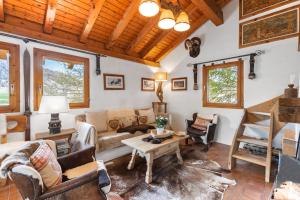 un soggiorno con divano e tavolo di Chalet Chesa Collina with Sauna a La Punt-Chamues-ch