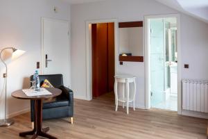 Sala de estar con silla negra y mesa en Golf- und Wellnesshotel Amtsheide, en Bad Bevensen