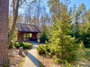 una cabaña de madera en el bosque con una pasarela en Resort Stariy Prud en Filippovichi