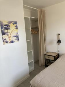 a bedroom with a bed and a painting on the wall at Maison de plein pied proche mer, marais et foret in Olonne-sur-Mer