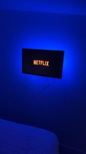 a sign that says netflix on a blue wall at Welcome to the black and White in Villepinte
