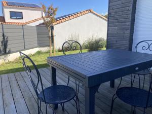 a blue table and chairs on a patio at Maison de plein pied proche mer, marais et foret in Olonne-sur-Mer +6 photos
