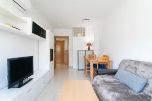 een woonkamer met een bank, een tv en een tafel bij Alicante Hills in Alicante