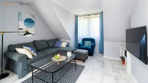 a living room with a couch and a tv at Wonder Home - Apartamenty z prywatnymi saunami, w zielonej części Karpacza in Karpacz