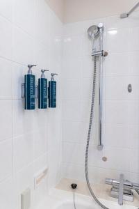 łazienka z prysznicem i 3 niebieskimi butelkami na ścianie w obiekcie Hilton Odawara Resort & Spa w mieście Odawara