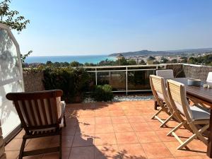 un patio con mesa, sillas y el océano en Villa Alex Altafulla Hermosa casa con espectaculares vistas al mar y a tocar de una idílica calita, en Altafulla