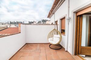 a swing on a balcony with a view of the city at Hotel Reina Mora in Granada