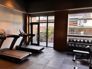 un gimnasio con dos máquinas de correr y una ventana en Episode Daan Taipei, JdV by Hyatt Hotel, en Taipéi