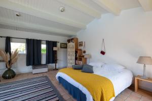 a bedroom with a large bed with a yellow blanket at Maison de famille donnant sur le Golf et le Fier d'Ars dans un parc de 7500m2 in Les Portes +19 photos