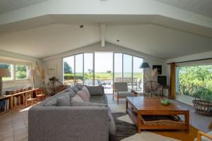 a living room with a couch and a table at Maison de famille donnant sur le Golf et le Fier d'Ars dans un parc de 7500m2 in Les Portes