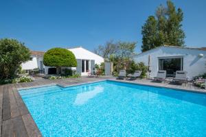 una piscina con sillas y una casa en Maison de famille donnant sur le Golf et le Fier d'Ars dans un parc de 7500m2, en Les Portes