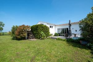 a white house with a grass yard at Maison de famille donnant sur le Golf et le Fier d'Ars dans un parc de 7500m2 in Les Portes