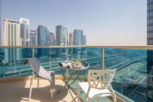 een balkon met een tafel en twee stoelen en een stad bij Frank Porter - Yach Bay in Dubai