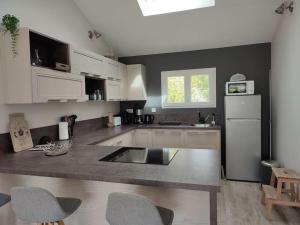 LanchèresにあるLes étoiles de la Baieの白いキャビネットとカウンタートップを備えたキッチン