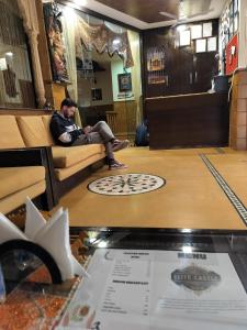 a man sitting on a couch in a waiting room at The Elite Castle in Jaisalmer
