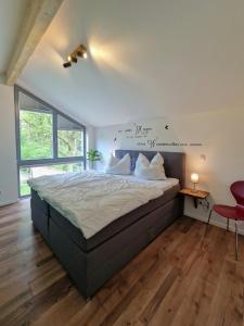 1 dormitorio con 1 cama grande con sábanas blancas en Waldhaus Tiedtke, en Wedemark