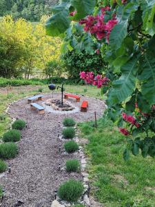 a garden with a fire pit and benches and flowers at Mészi Vendégház in Zalacsány