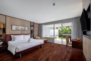 a hotel room with a bed and a television at Sanur Resort Watujimbar in Sanur