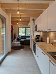 eine Küche mit weißen Schränken und ein Wohnzimmer in der Unterkunft Waldhaus Tiedtke in Wedemark