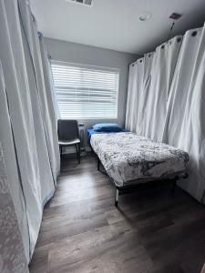 Zimmer mit 2 Betten und einem Fenster mit Vorhängen in der Unterkunft Westminster Zen Home in Westminster