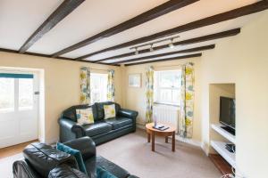 圣艾夫斯Tregenna Castle Self Catering的客厅里有一张黑色皮沙发和一台电视