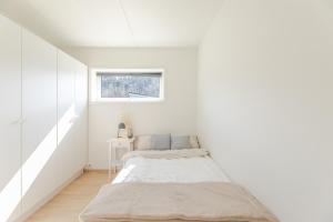 biały pokój z łóżkiem i oknem w obiekcie Nydelig selveier leilighet med gratis parkering på stedet w Alcie