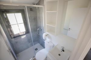 een badkamer met een douche, een toilet en een wastafel bij Camping Urbion in Abejar